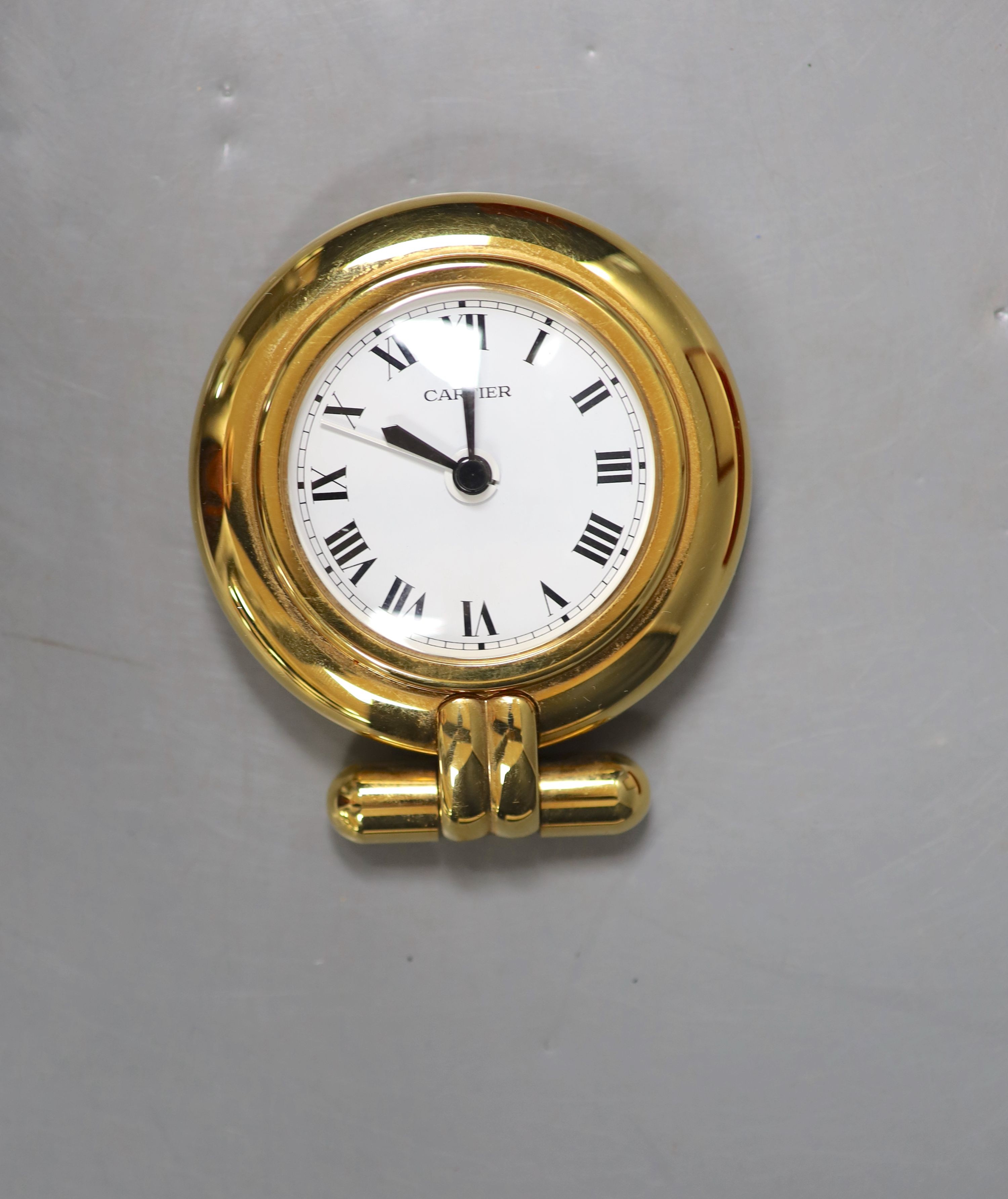 A cased Cartier gilt metal travelling timepiece